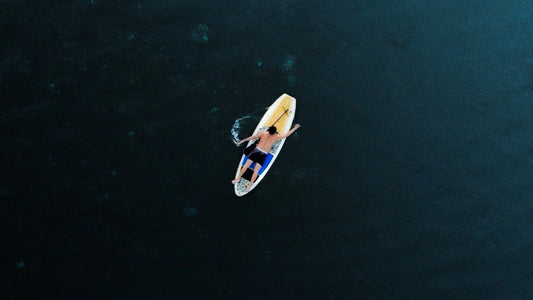 A guy lying down on his paddleboard